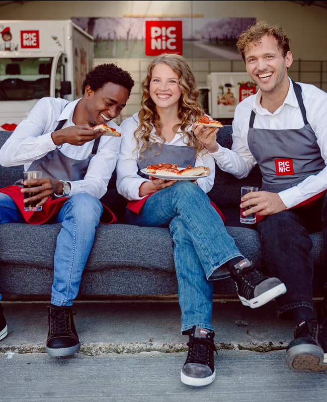 Picnic employees eating pizza together